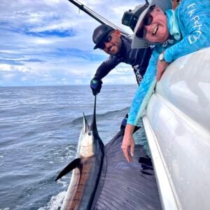 Guests and crew with a sailfish at the boat on a Majo Pro Fishing charter